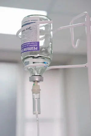 Капельница на фоне больничной палаты