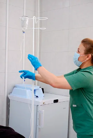 Пациент лежит под капельницами