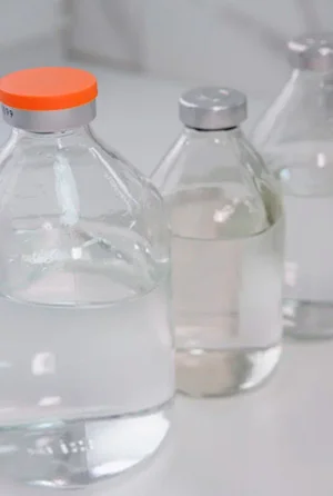 Ампулы и шприц на белом столе